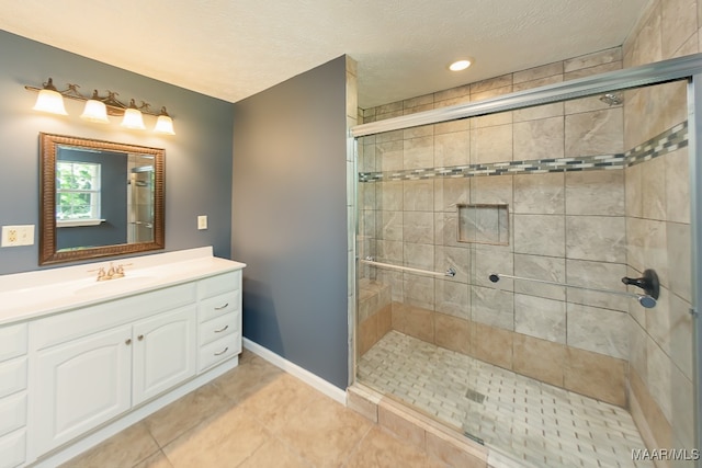 bathroom featuring tile patterned floors, an enclosed shower, vanity, and a textured ceiling