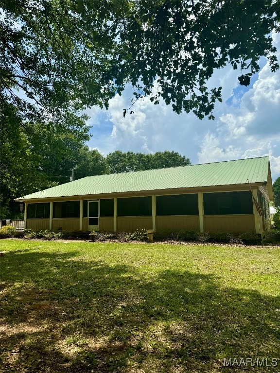 rear view of property featuring a yard