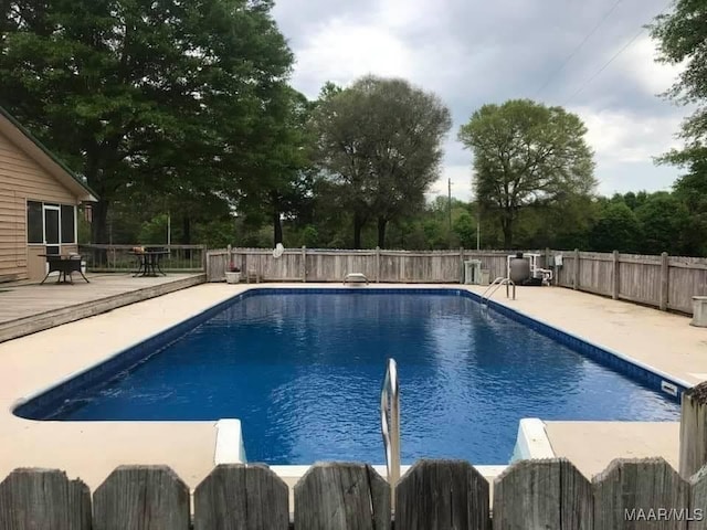 view of swimming pool with a diving board