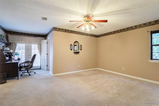 unfurnished office with visible vents, a ceiling fan, a textured ceiling, and light colored carpet