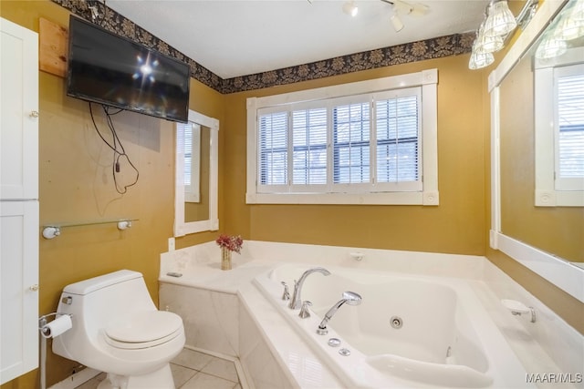 bathroom with a wealth of natural light, tile patterned flooring, tiled tub, and toilet