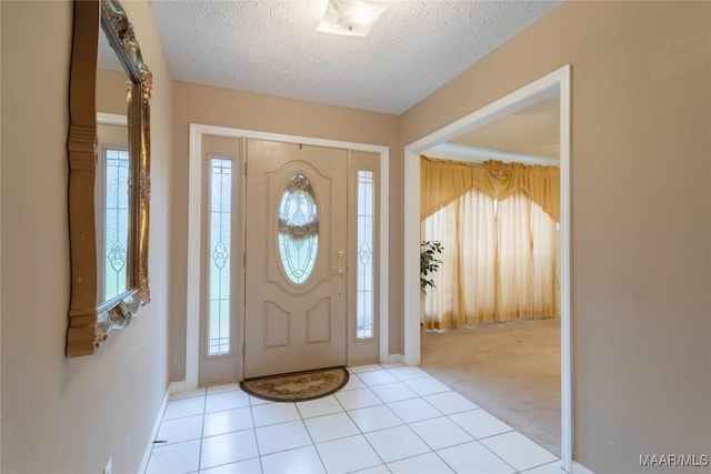 entryway featuring baseboards, plenty of natural light, a textured ceiling, and light colored carpet
