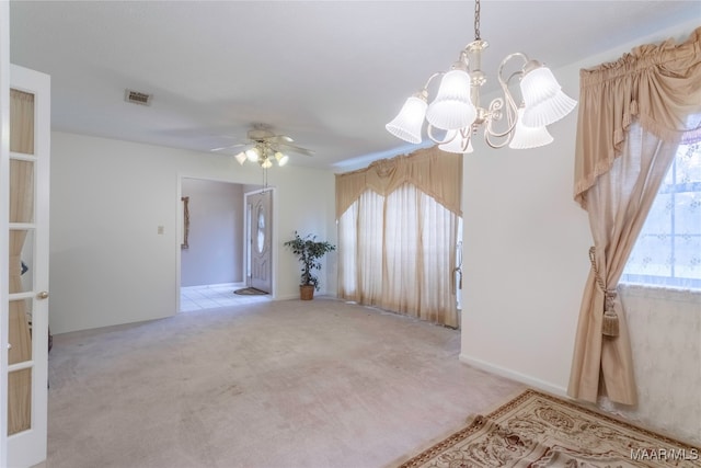 spare room with light carpet and ceiling fan with notable chandelier