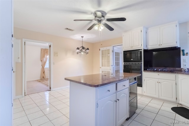 kitchen with black appliances, ceiling fan with notable chandelier, a center island, and white cabinetry