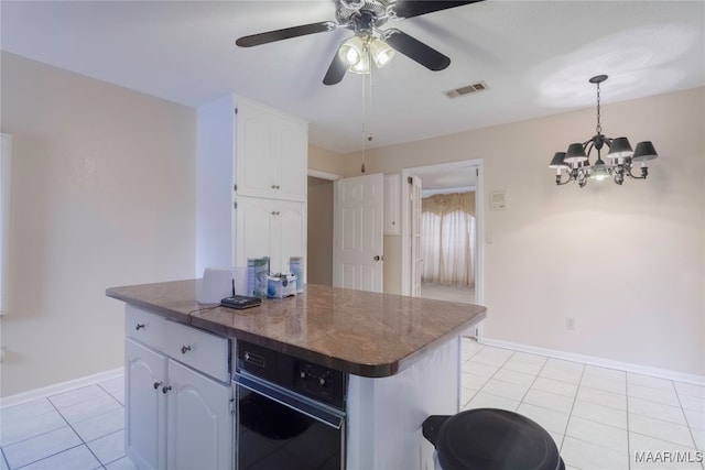 kitchen featuring ceiling fan with notable chandelier, a center island, light tile patterned floors, and white cabinets