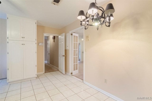 interior space featuring an inviting chandelier, baseboards, light tile patterned floors, and visible vents