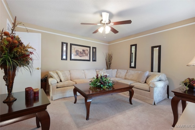 living room with ceiling fan, light colored carpet, and ornamental molding