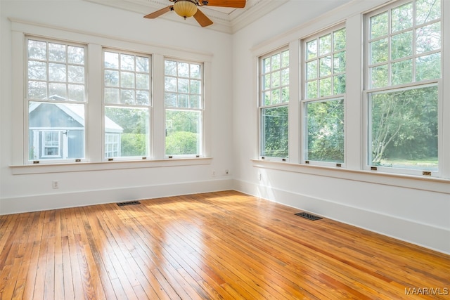 empty room with ceiling fan, hardwood / wood-style flooring, and a wealth of natural light