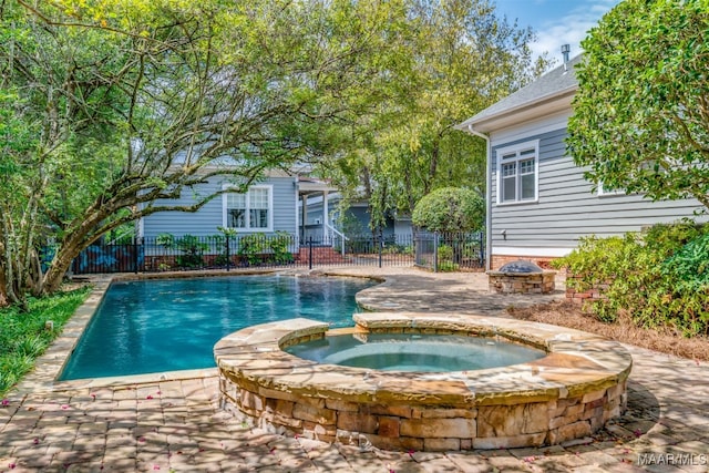 view of swimming pool featuring an in ground hot tub and an outdoor fire pit