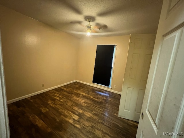 empty room with ceiling fan, a textured ceiling, and dark hardwood / wood-style flooring