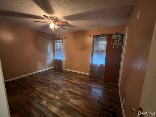 unfurnished room featuring a textured ceiling, ceiling fan, and dark hardwood / wood-style flooring