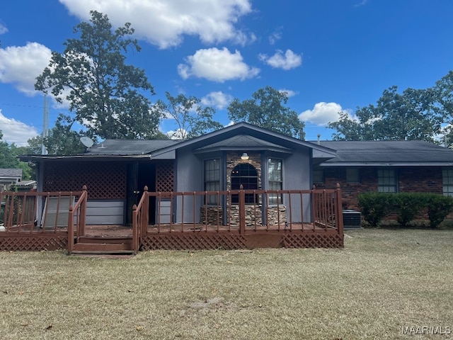 rear view of property featuring a yard and a wooden deck