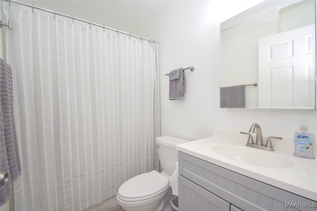 bathroom with a textured ceiling, vanity, and toilet