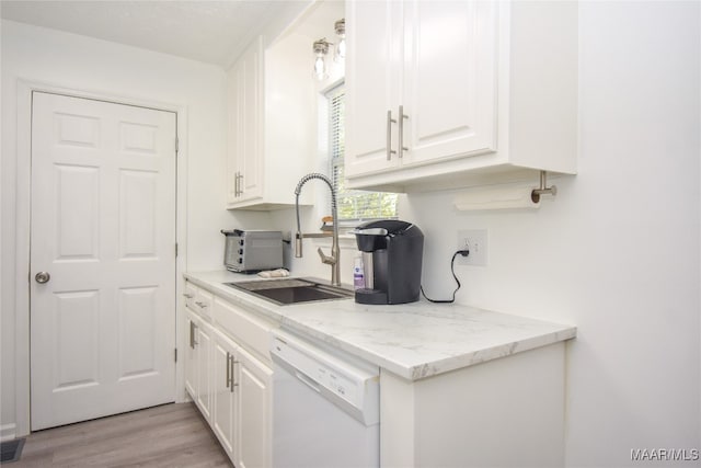 kitchen featuring light stone countertops, white dishwasher, light hardwood / wood-style flooring, and white cabinetry