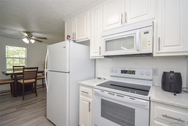 kitchen featuring a textured ceiling, white cabinets, light hardwood / wood-style flooring, white appliances, and ceiling fan