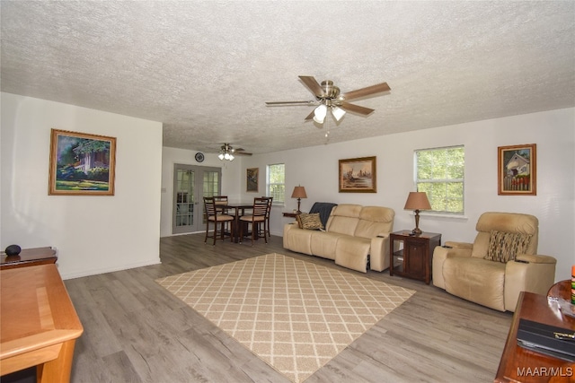 living room with wood-type flooring, ceiling fan, and a wealth of natural light