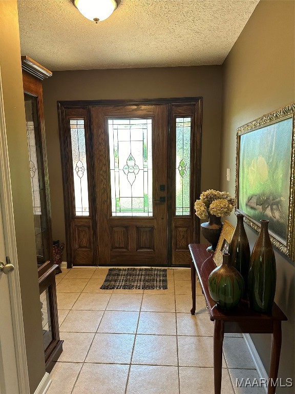 tiled foyer entrance featuring a textured ceiling