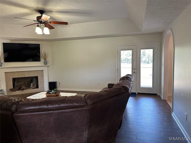 414 Warrior Dr, Valley Grande, AL 36701 - living area featuring a textured ceiling, baseboards, ceiling fan, a fireplace, and arched walkways
