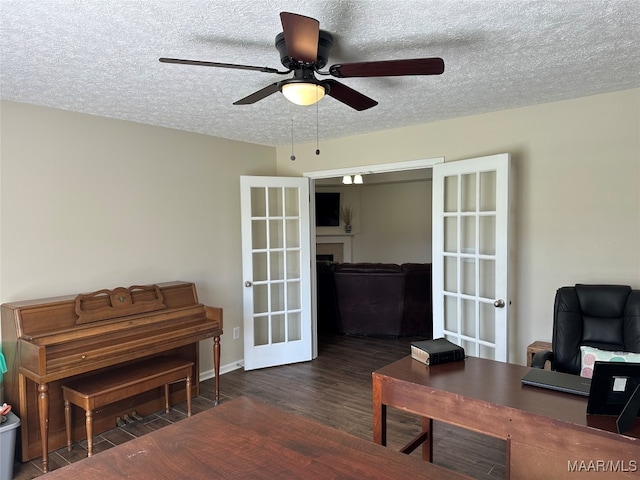 home office featuring french doors, a textured ceiling, dark wood-type flooring, and ceiling fan