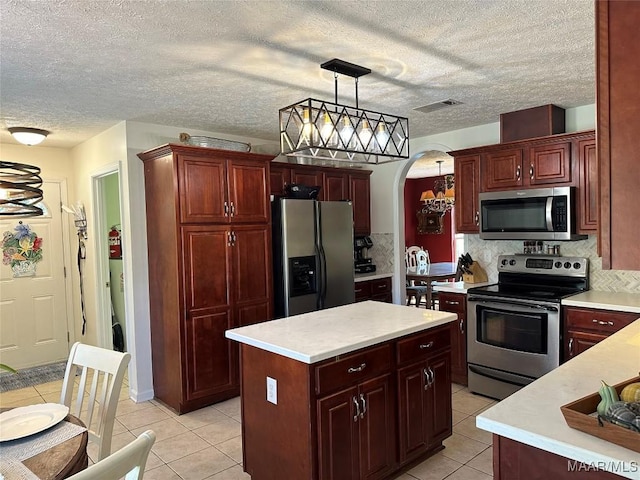 414 Warrior Dr, Valley Grande, AL 36701 - kitchen featuring stainless steel appliances, arched walkways, light tile patterned floors, light countertops, and decorative light fixtures