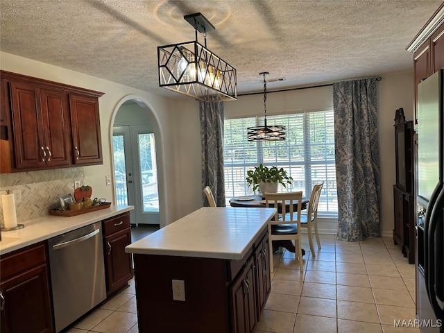 kitchen with decorative light fixtures, appliances with stainless steel finishes, a center island, and a healthy amount of sunlight