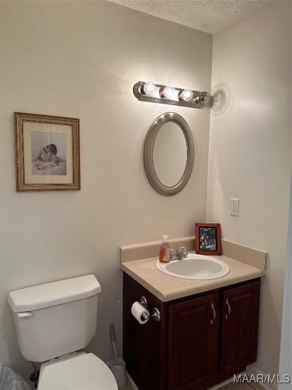 414 Warrior Dr, Valley Grande, AL 36701 - half bath with vanity, a textured ceiling, and toilet