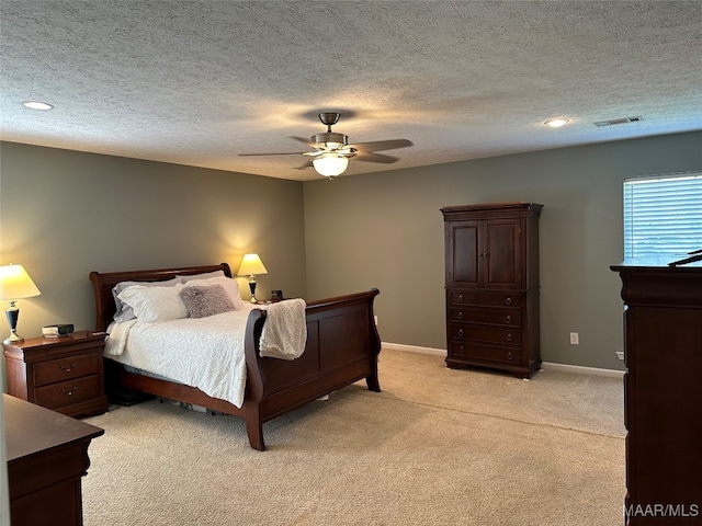 carpeted bedroom featuring ceiling fan and a textured ceiling