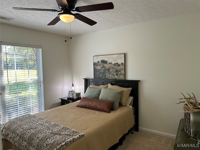 bedroom featuring a textured ceiling, carpet, and ceiling fan