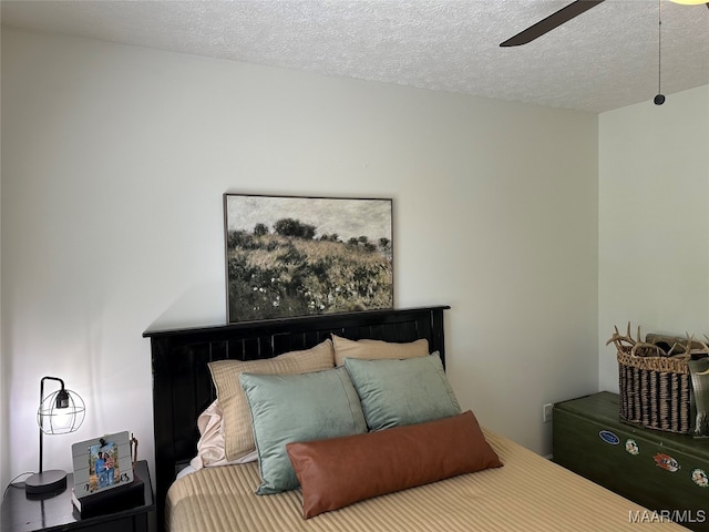 bedroom with ceiling fan and a textured ceiling