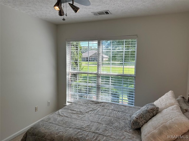 414 Warrior Dr, Valley Grande, AL 36701 - carpeted bedroom with a textured ceiling, baseboards, and a ceiling fan