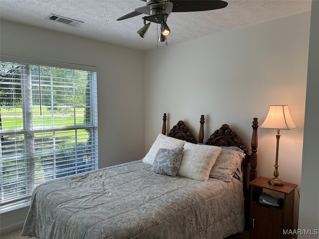 bedroom featuring a textured ceiling, carpet, and ceiling fan