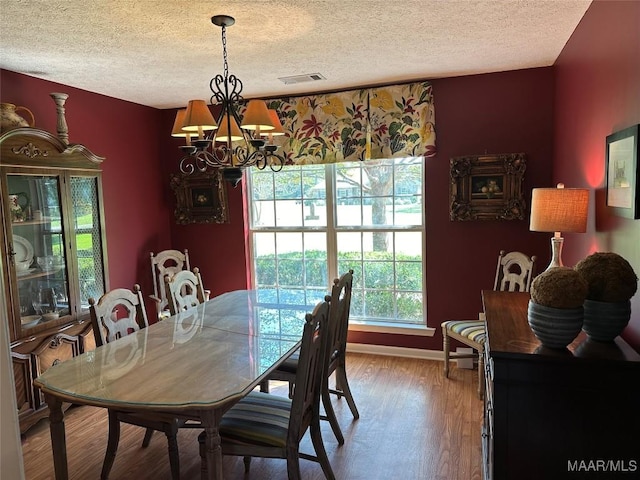 414 Warrior Dr, Valley Grande, AL 36701 - dining room featuring a chandelier, a textured ceiling, plenty of natural light, wood finished floors, and baseboards