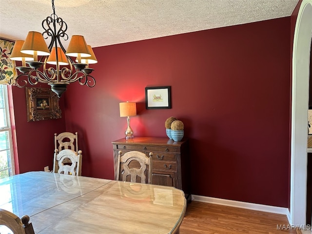 dining room featuring an inviting chandelier, a textured ceiling, and hardwood / wood-style floors