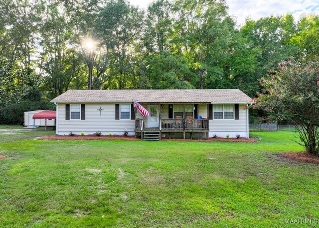 single story home featuring a front lawn, an outdoor structure, and covered porch