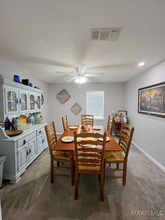 dining room featuring carpet, visible vents, a ceiling fan, a textured ceiling, and baseboards