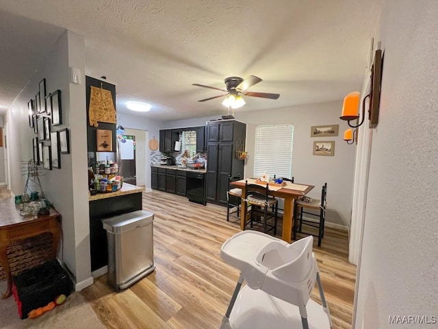 dining space featuring a textured ceiling, ceiling fan, light wood-type flooring, and baseboards