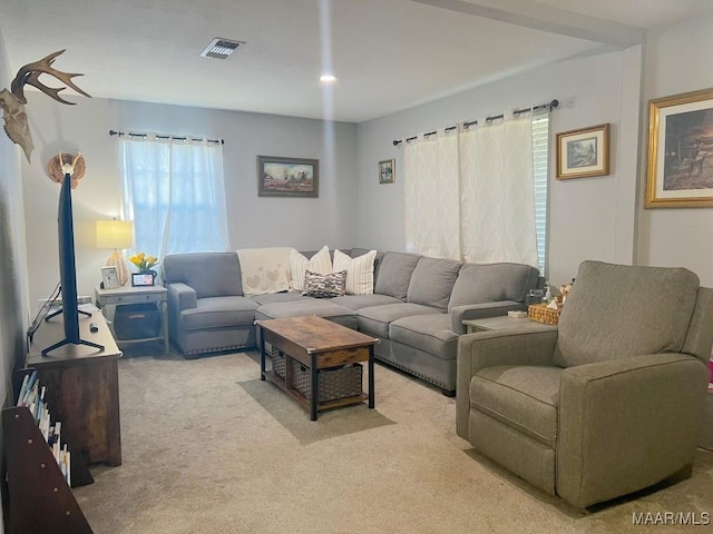 living area with visible vents and light colored carpet