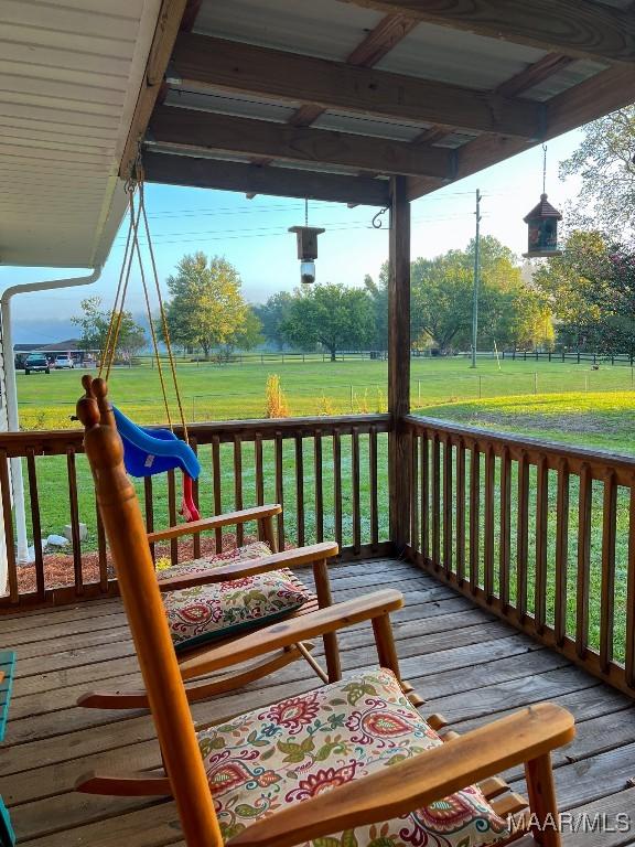 deck with a yard, a playground, and fence