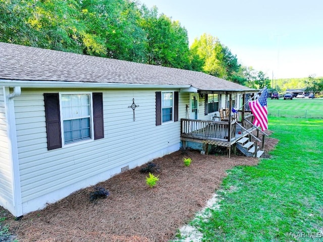 ranch-style house with a front yard, crawl space, roof with shingles, and covered porch