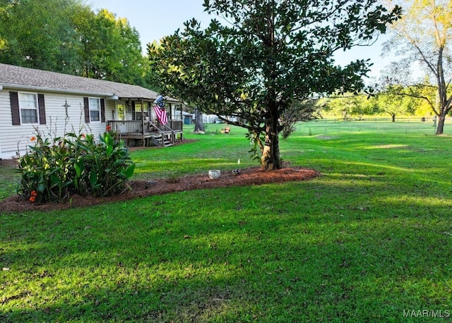 view of yard with a deck and fence