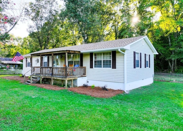 single story home featuring a porch, a front yard, fence, and a shingled roof