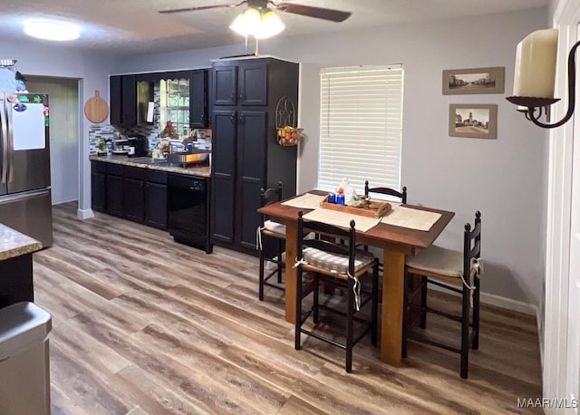 dining space with a ceiling fan, light wood-style flooring, and baseboards