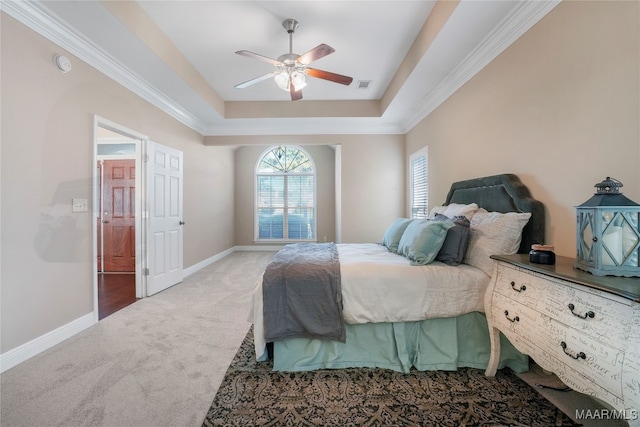 bedroom with carpet floors, crown molding, a tray ceiling, and ceiling fan