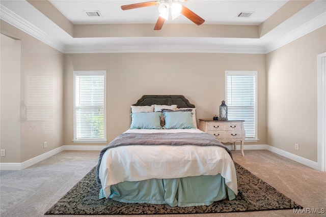 bedroom with a tray ceiling, ceiling fan, light colored carpet, and crown molding