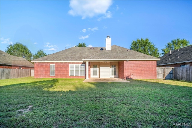 rear view of property with a patio and a yard