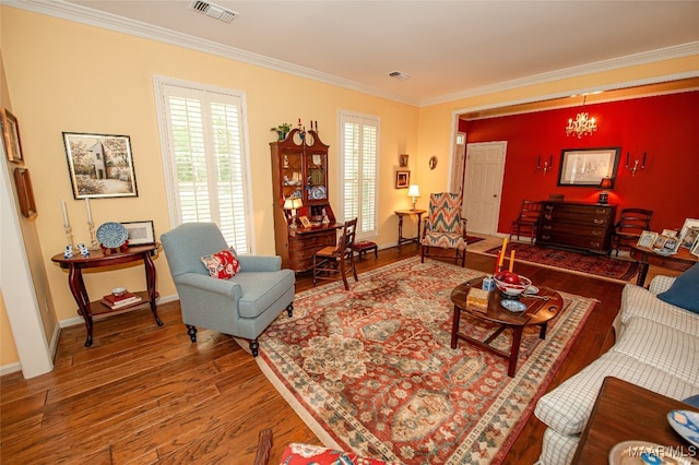 living room with a notable chandelier, crown molding, and hardwood / wood-style flooring