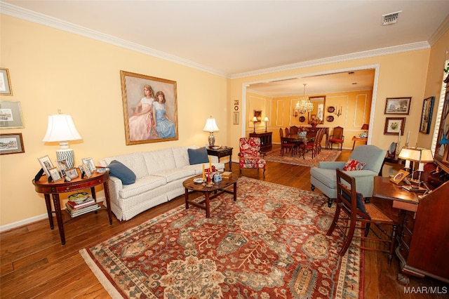 living room with a notable chandelier, crown molding, and hardwood / wood-style floors