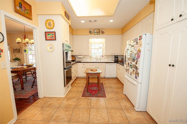 kitchen featuring light tile patterned flooring, a notable chandelier, white cabinetry, decorative backsplash, and white appliances