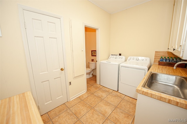 laundry room with light tile patterned flooring, separate washer and dryer, and sink