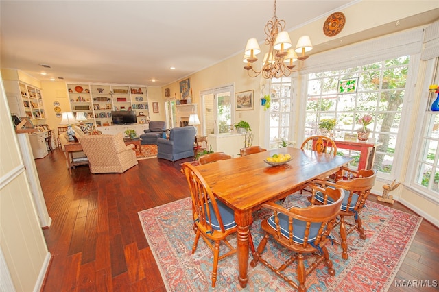 dining room featuring an inviting chandelier, built in features, dark wood-type flooring, and crown molding